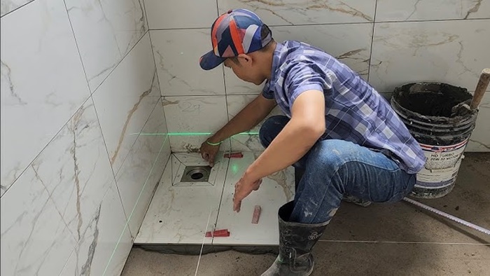 Thợ của Kỹ Thuật 24h đang thi công ốp lát gạch men cho phòng tắm